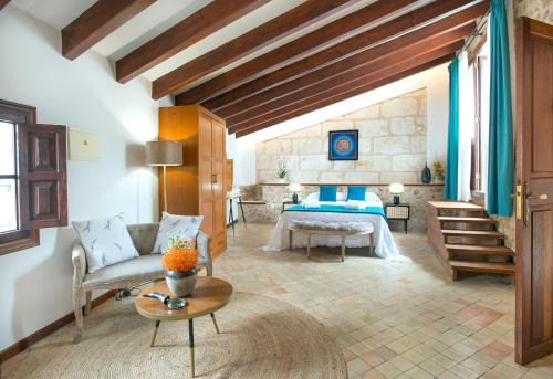 凯玛丽Petit Caimari - Turismo de interior的一间卧室配有一张床、一张沙发和一张桌子