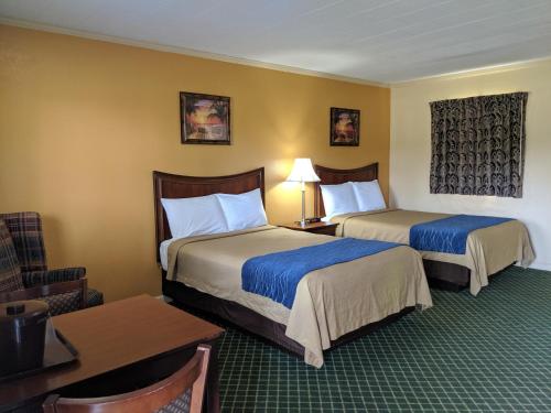 Glennville格伦维尔奇瑞奥酒店的酒店客房设有两张床和一张桌子。