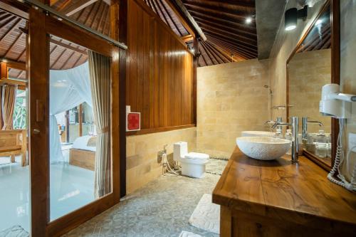 乌布眼镜蛇私人别墅 的浴室配有盥洗盆、卫生间和浴缸。