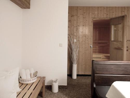 埃布斯Unterwirt - Das kleine Gourmethotel的卧室设有白色墙壁、桌子和长凳