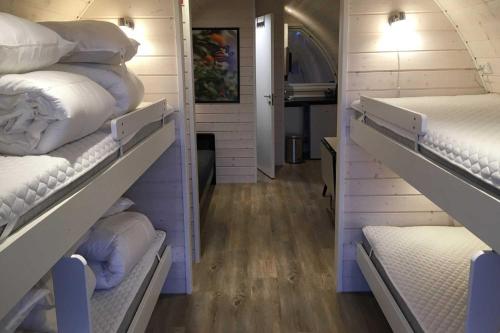 KjellerupNaturhytter的一间设有两个架子的房间,上面装有白色床垫