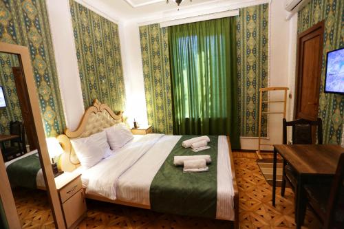 库塔伊西Sanapiro Hotel的一间卧室配有一张床,上面有两条毛巾