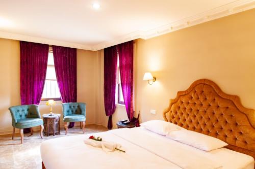 尚勒乌尔法ÂLÂ HAN BOUTIQUE HOTEL的酒店客房带一张大床和两张椅子
