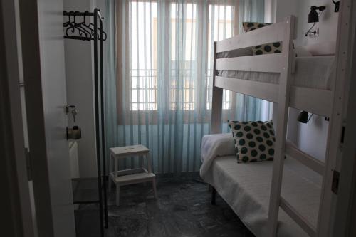 卡斯特里尔Alojamiento Rural La Cochera的一间卧室配有双层床和窗户。