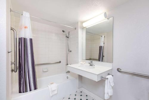 埃尔帕索埃尔帕索西部拉金塔旅馆的白色的浴室设有水槽和淋浴。