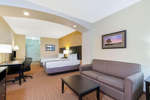斯蒂尔沃特La Quinta by Wyndham Stillwater -University Area的酒店客房配有一张床、一张沙发和一张书桌。