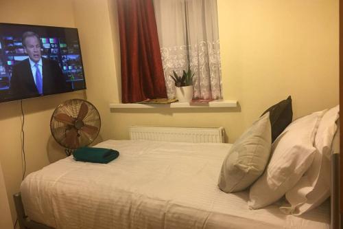 伦敦F3 Cosy Single Room (Sandycroft Guest House)的卧室配有一张床铺,墙上配有电视