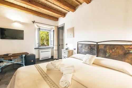 洛特佐拉伊Sa Crai B&B - Sardinian Experience的一间卧室设有两张床,墙上配有电视。