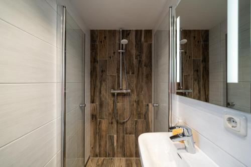 奥茨塞巴德·迪尔哈根Haus Windhook的带淋浴、盥洗盆和镜子的浴室
