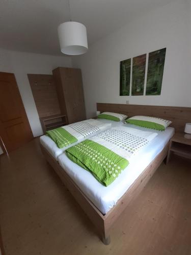 RoggendorfLandhof Lydia的一间卧室配有一张带绿色枕头的大床
