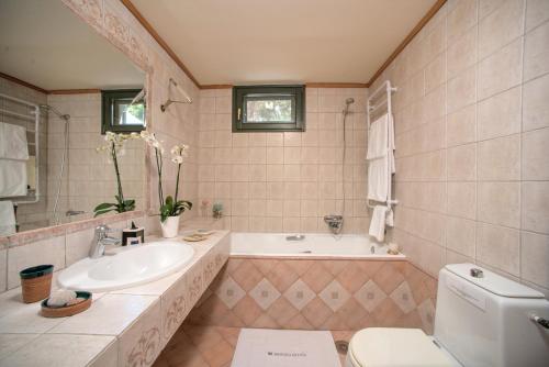 Porto OziasBasilica Estate的一间带水槽、浴缸和卫生间的浴室