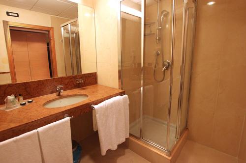 奥佩拉米兰高尔夫酒店的带淋浴和毛巾水槽的浴室