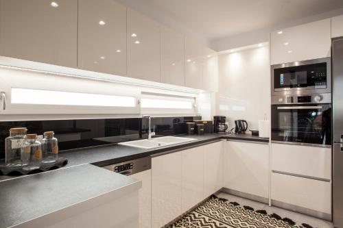 海若克利欧Emfasis Loft Spacious and Elegant Heraklion的厨房配有白色橱柜和炉灶烤箱。