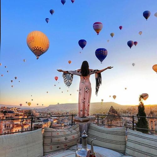 阿瓦诺斯萨克里窑洞旅馆的站在有气球的塔顶上的女人