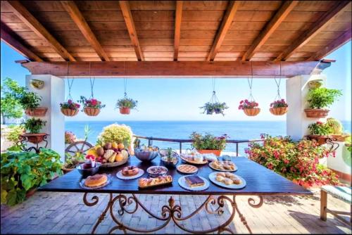 伊斯基亚B&B Villa Antica的露台的餐桌,背景是大海