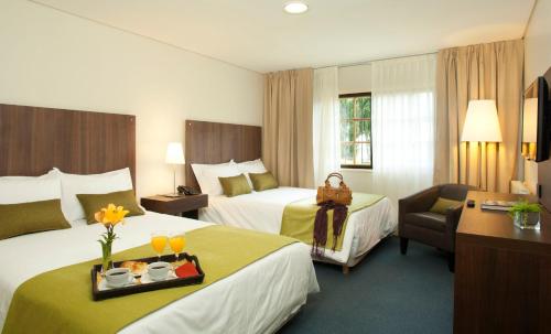 埃尔卡拉法特巴伊亚雷东达酒店的一间酒店客房,配有两张床和一盘食物