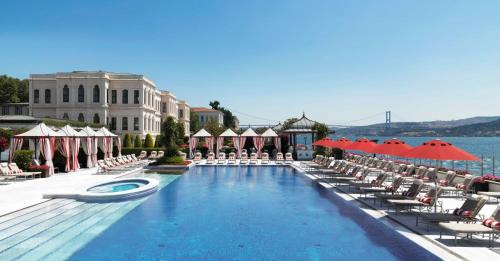 伊斯坦布尔伊斯坦布尔博斯普鲁斯海峡四季酒店的一个带椅子和遮阳伞的大型游泳池