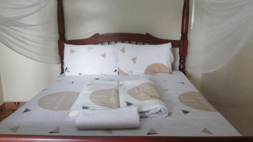 KobokoRock Shadow Hotel的一张带毛巾和枕头的床
