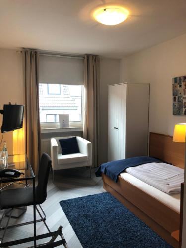 亚琛bensons hotel的卧室配有床、椅子和窗户。