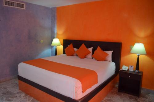 图斯特拉古铁雷斯玛丽亚欧亨尼娅酒店的一间卧室配有一张带橙色墙壁的大床