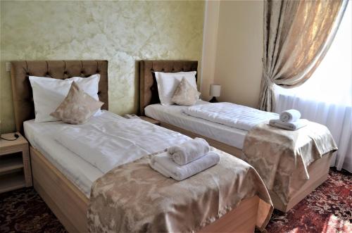 福克沙尼Pensiunea Romeo Resort的一间卧室配有两张带毛巾的床