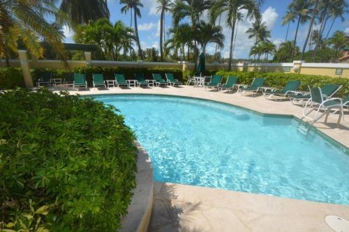 乌马考Beach Villa 215的一个带椅子的游泳池,棕榈树