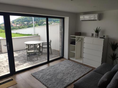 西格利盖特Panorama & Vino apartman的带沙发和桌子的客厅以及阳台。