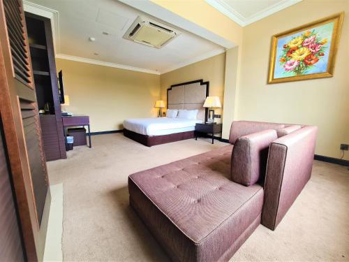 居銮默迪卡居銮酒店的酒店客房,配有床和沙发