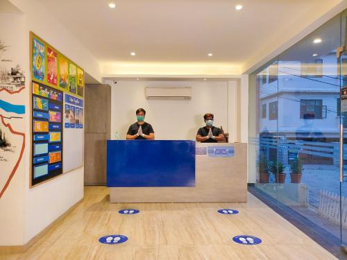 瑞诗凯诗Blue Jay Hostel Rishikesh的两个人戴面具坐在柜台