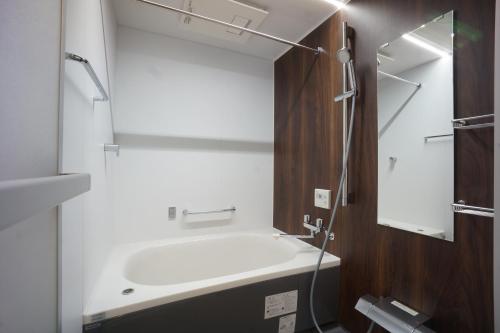 东京WIRES HOTEL James zaka的浴室配有白色浴缸和镜子
