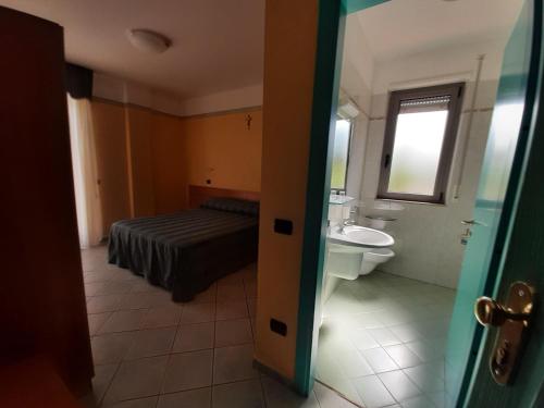 圣乔瓦尼·罗通多Hotel Pegaso的一间带床、水槽和卫生间的浴室