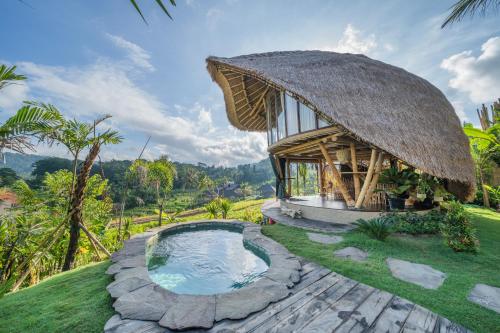 希德门Veluvana Bali的草原上带游泳池的小小屋