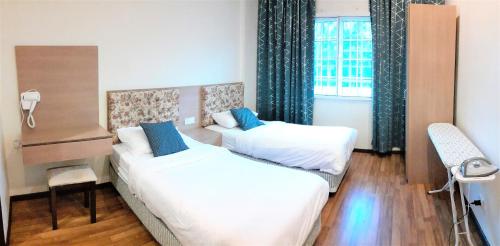 金马仑高原提亚斯公寓@艾利斯之家度假村的酒店客房设有两张床和窗户。