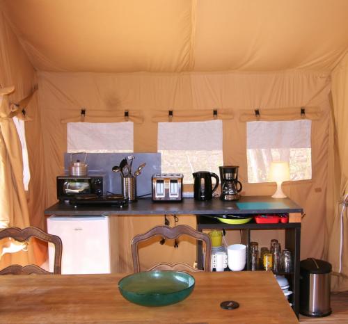 FeusinesSafaritent Les Pourettes的帐篷内的厨房配有桌子和台面