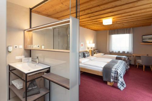 哈莱因附近普赫珠姆凯辰威尔泰酒店的一间卧室配有床、水槽和镜子