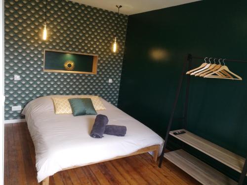 迪耶普Villa Carlotta - Sea resort的一间卧室配有一张白色的床和绿色的墙壁