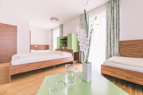 Königswiesen卡林格豪斯旅馆的一间卧室配有两张床和一张桌子及眼镜