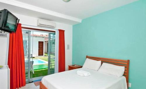 纳塔尔意大利旅馆的一间卧室设有一张带电视的床和一个游泳池。