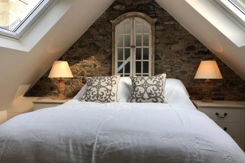 皮布尔斯Barns Bothy的一间卧室配有一张带两盏灯的大型白色床。