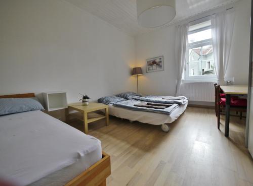 格拉茨Ferienzimmer 2021的一间卧室设有两张床、一张桌子和一个窗口。