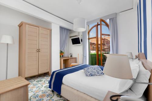 埃尔科拉诺赫库兰尼姆酒店的配有一张床和一把椅子的酒店客房