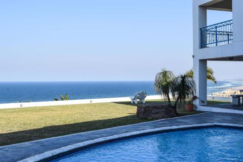阿曼济姆托蒂Santorini Guesthouse的一座背景海洋的游泳池