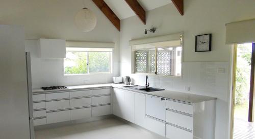彭特派因Pitcairn House的白色的厨房配有白色橱柜和窗户