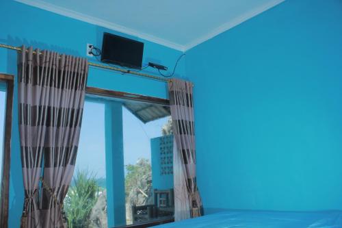 Tepus奥曼哈桑丹克民宿的客房设有带电视的大窗户。
