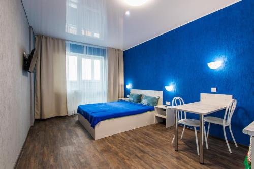 巴尔瑙尔22-HOTEL的蓝色卧室,配有床和桌子