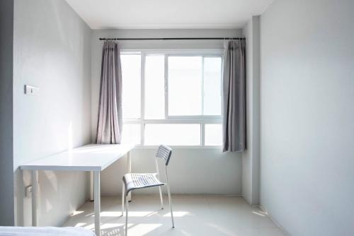 曼那拉塞尔59NW公寓式酒店的窗户客房内的白色桌子和椅子