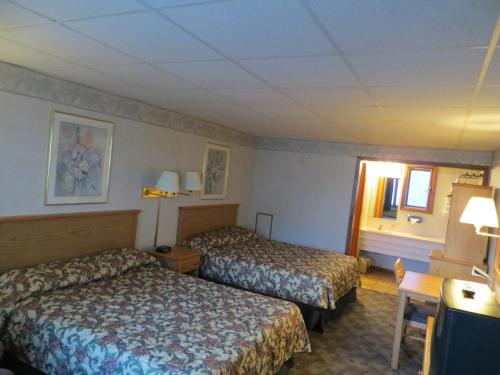 科尔尼Midtown Western Inn - Kearney的酒店客房设有两张床和窗户。