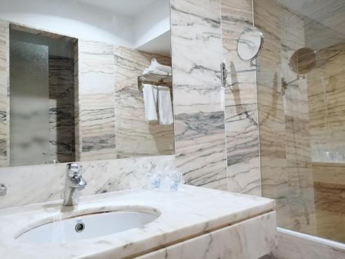 阿尔赫西拉斯米尔奥克塔维酒店的一间带水槽和玻璃淋浴的浴室