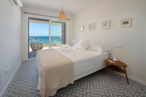 科洛尼亚圣霍尔迪BLAU Apartamento en Cala Galiota con vistas al mar的一间卧室设有一张床,享有海景