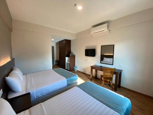 Kampong TambakKSB Village Resort的酒店客房配有两张床和一张书桌